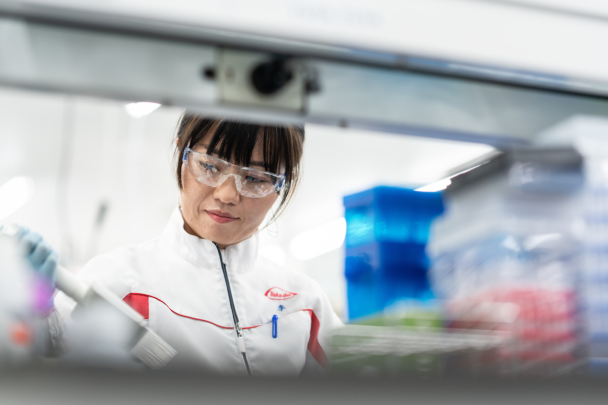 Un scientifique qui porte des lunettes de sécurité et qui effectue des recherches scientifiques dans un laboratoire en tenant un outil.