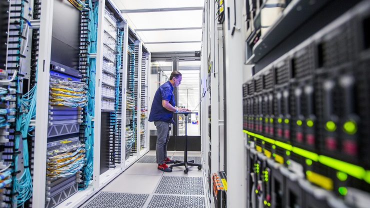 Un travailleur qui vérifie les statistiques dans le système de stockage de données à l’installation de la Coalition pour la science des données