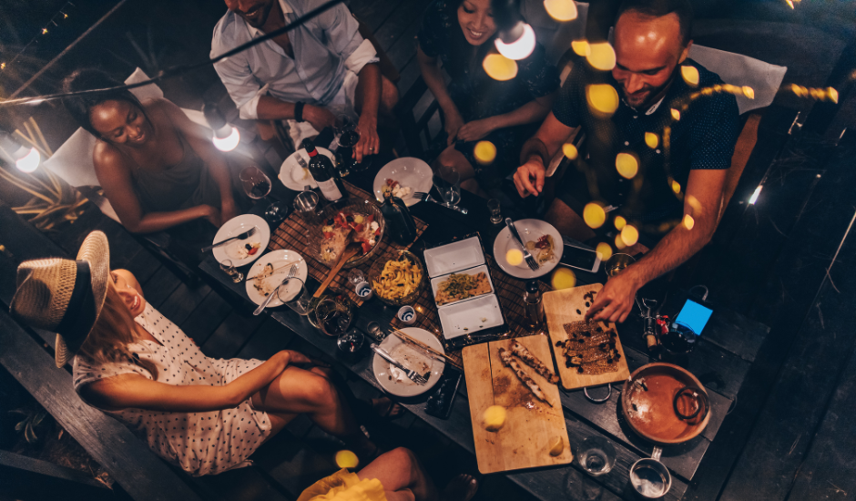 A group of adults eating dinner in the summer on an outdoor patio in Toronto, Ontario