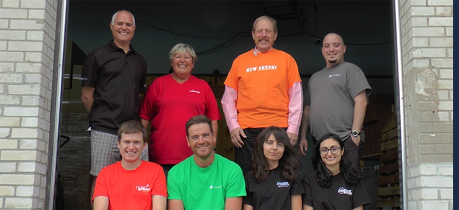 Des employés souriants de Payment Source, qui portent des t-shirts de couleurs différentes.