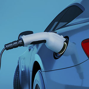 Véhicule électrique bleu branché à un chargeur de batterie