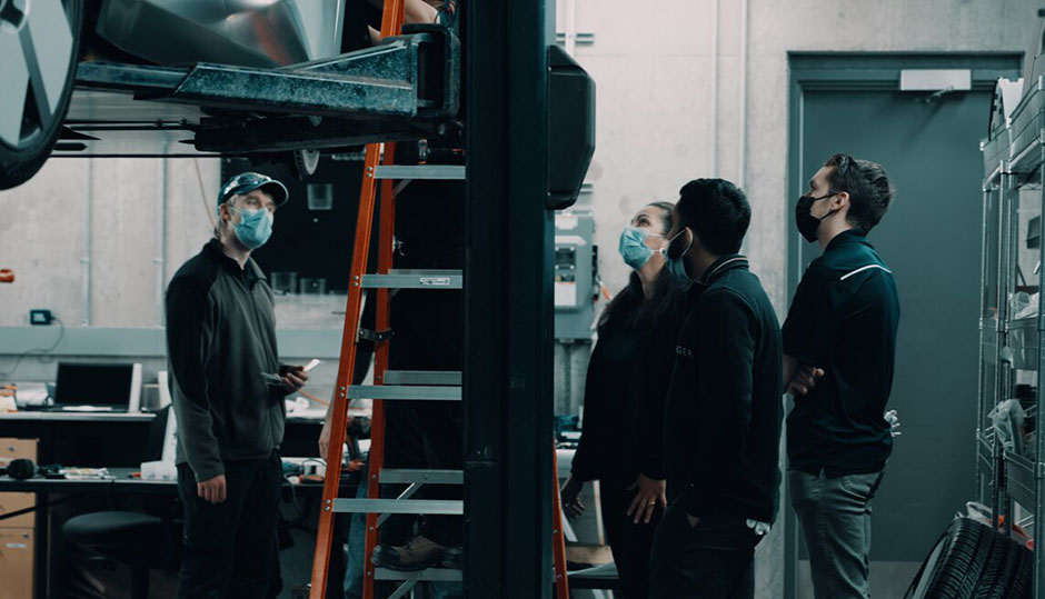 Workers observing the car’s assembly process.
