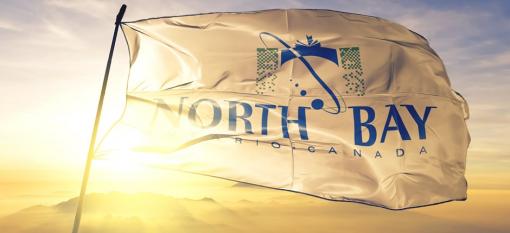 Drapeau de North Bay, Ontario agitant au sommet d'un lever de soleil